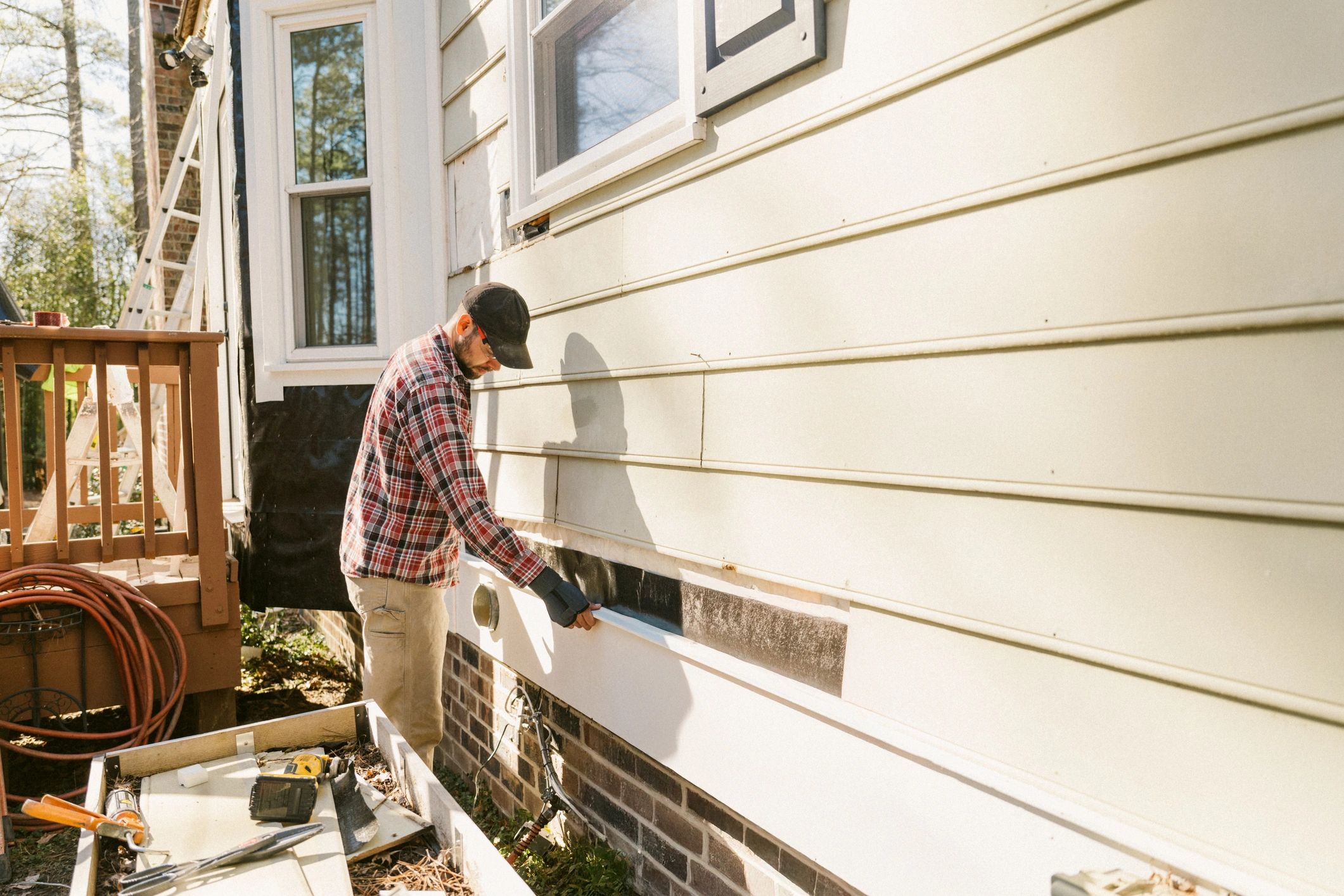 Technician working on exterior repair at a property
